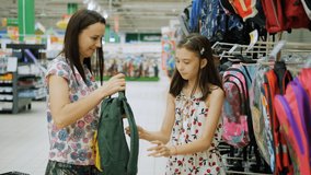 Mom tries on a new school backpack for her daughter before the new school year. - Powered by Shutterstock - Get 15% off with code: PIKWIZARD15