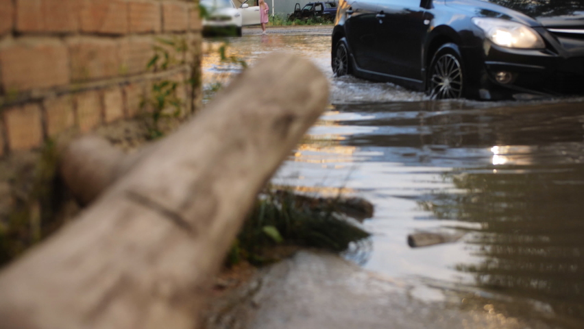 City roads flooded by a downpour. The car drives through a huge puddle. Royalty-Free Stock Footage #1092748459