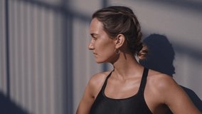 Cinematic action footage of a sport woman training and doing fitness exercises outdoor in an urban area of the city. Concept about running and active workouts
