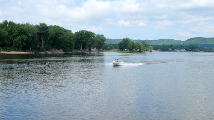 Pleasure boat speeds past a floating buoy on the Mississippi River at La Crosse, Wisconsin.
