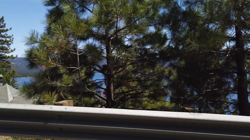 Lake Tahoe, Sierra Nevada USA. Driving POV of Coastline, Conifer Trees and Waterfront Properties