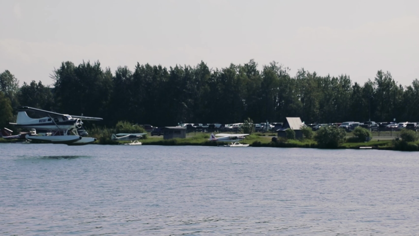 Float Plane Landing At The Lake Hood Seaplane Base In Anchorage, Alaska. pan right, tracking shot
