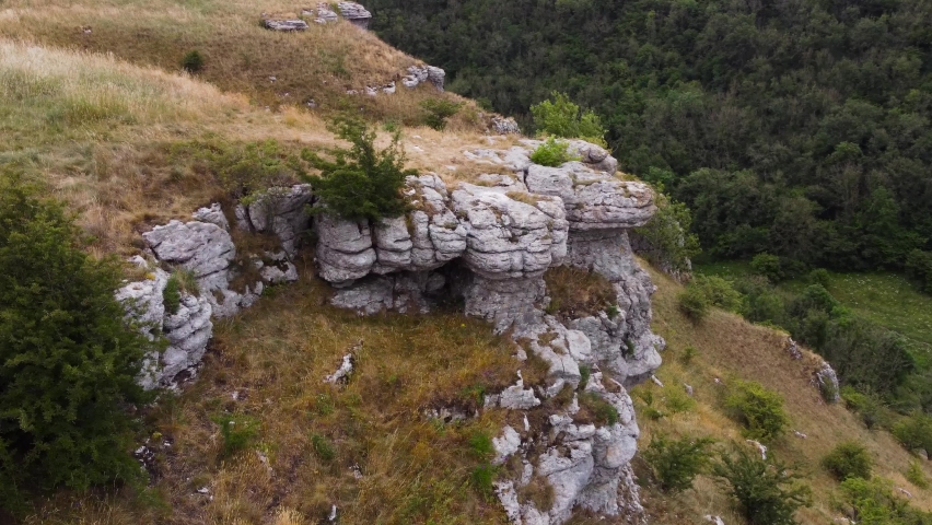 Aerial view across rugged stone rock formation on Peak district forested hillside