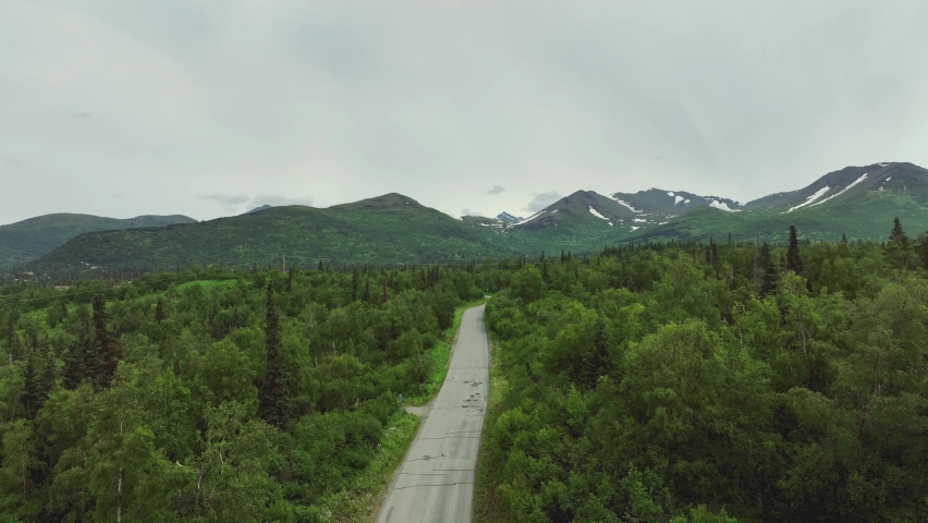 Aerial View Of Country Road With Snow Mountains At Background On Anchorage Countryside In Alaska.