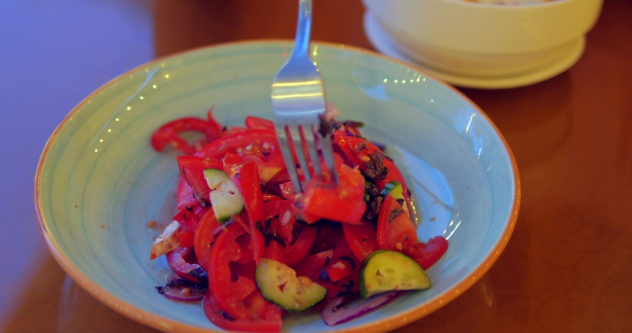 Close-up view of girl 's hands eating healthy vegeterian salad in cafe