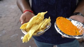 Video of man with no face holding crispy Fafda with sweet jalebi, a popular Indian snack. Kolkata