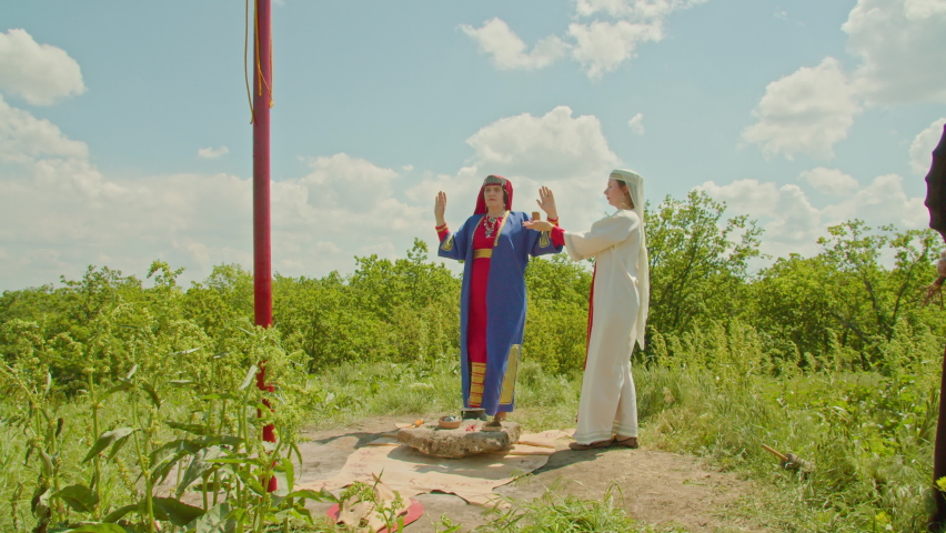 reconstruction of the pagan rite of sacrifice. the priestess and her assistant perform the ceremony, the shaman plays the tambourine. influence of paganism in the world.