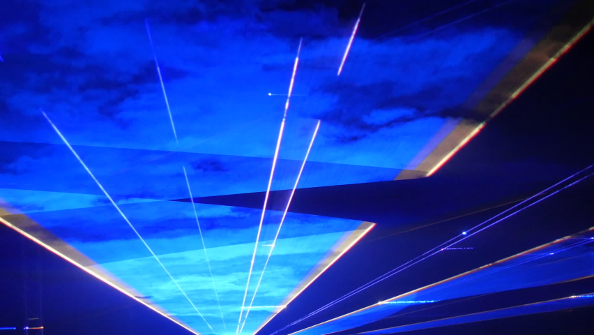 Light laser show on a black background of the night sky, outdoor performance. Multi-colored laser beams turn into various shapes, projection on smoke. Information Technology Conference