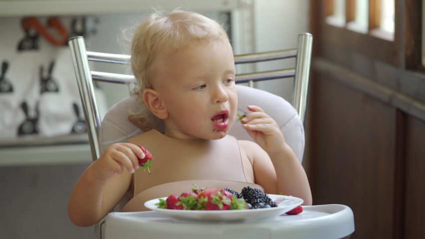 Eat berries. Ребенок ест варенье фото.