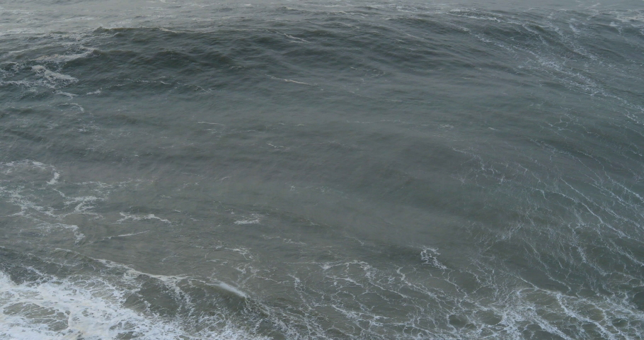 Big ocean waves coming to the coast and breaking with a massive splash. Seascape with rough water