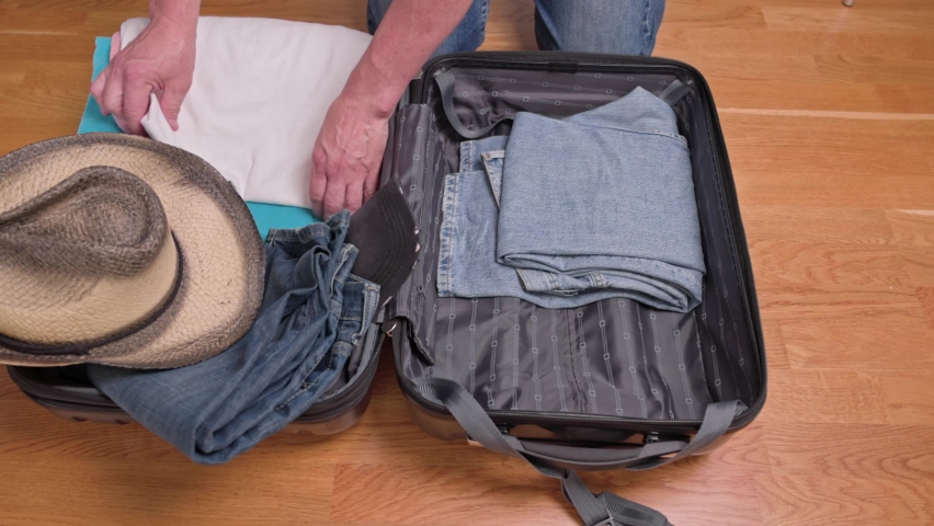Close up view of man packing clothes into suitcase for tourist trip. Sweden. | Shutterstock HD Video #1092787861