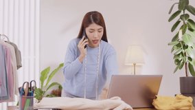 Asian designer woman uses his smartphone to communicate. Work on projects and papers. and work from home on a desk with a laptop. - Powered by Shutterstock - Get 15% off with code: PIKWIZARD15
