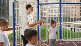 School coach mentoring kids how to catch and throw the ball on basketball court outdoor. Teaching commenting the game - Powered by Shutterstock - Get 15% off with code: PIKWIZARD15