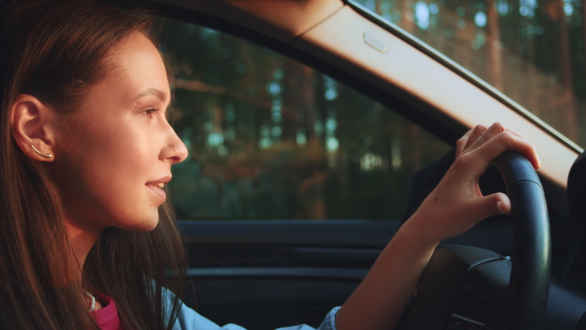 Young smile woman driving car and looking around at road traffic of green city. Adult girl having safety ride to job in vehicle. young woman travelling by car or camper van, open window breathe fresh | Shutterstock HD Video #1092808359