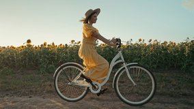 Rural woman in timeless dress riding retro styled white bicycle on country road alone near sunflowers field. Vintage fashion, amazing adventure, countryside activity, healthy lifestyle. - Powered by Shutterstock - Get 15% off with code: PIKWIZARD15