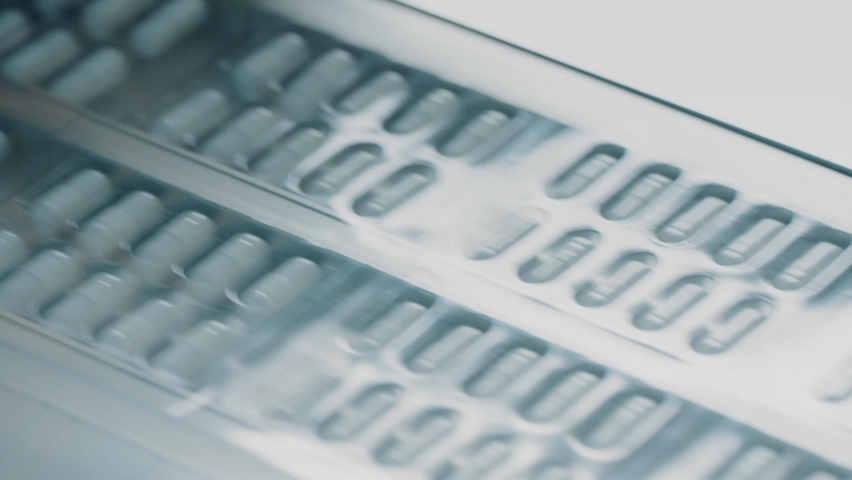4K Blister packs with medicinal capsules move along the conveyor. Stage of fabrication. Plastic package with capsule meds. Medication capsules in blisters. Pharmaceutical factory production line Royalty-Free Stock Footage #1092811601