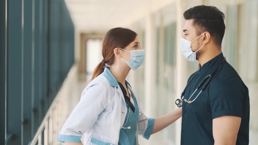 A nurse puts a protective mask on a doctor | Shutterstock HD Video #1092818271