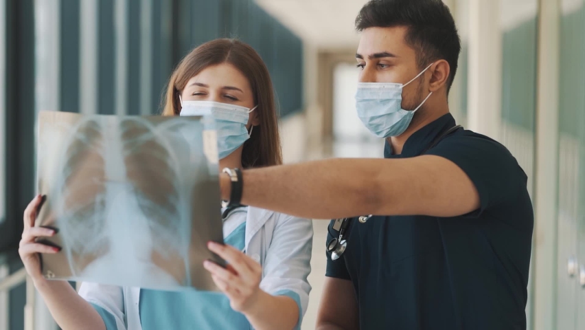 A doctor and a nurse are reviewing an x-ray of the lungs | Shutterstock HD Video #1092818285