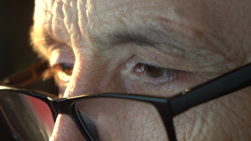 Close-up of the focused eyes of a businessman wearing computer glasses, looking at a reflective PC screen Royalty-Free Stock Footage #1092823717