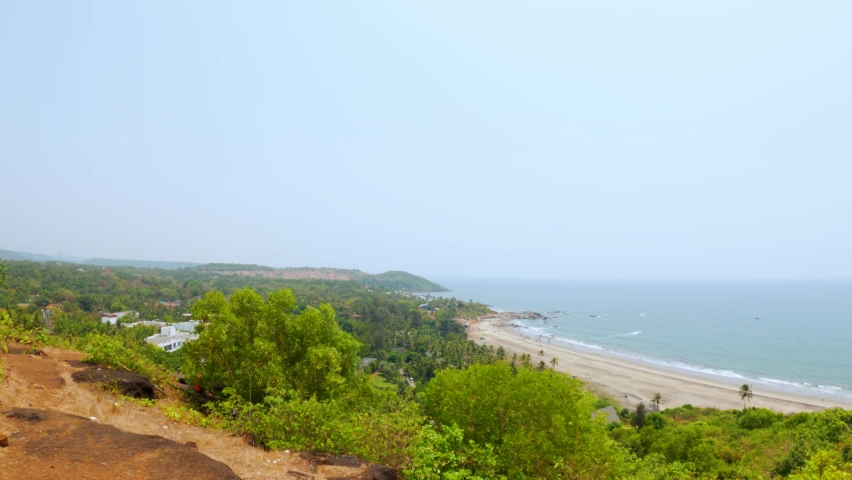 4K Wide angle shot of Vagator beach as seen from the top of the Chapora Fort at Goa in India. Wide angle shot of beach as seen from above. Blue sea in goa. Summer relaxation background.  | Shutterstock HD Video #1092826003