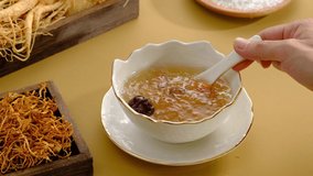 Cooking birdnest in bowl and yellow table  with traditional medicine ingredient , expensive and healthy content , video clip stock