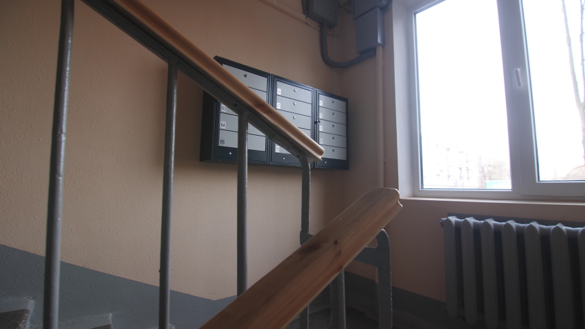 Metal mail boxes set hangs on wall on staircase of contemporary apartment building close view. Equipment for tenants