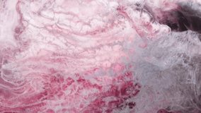 Abstract fantasy fluid art background. Swirling pink paint on a purple background. Macro video of pink smoke and clouds.