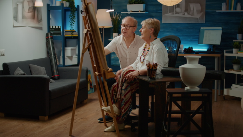 Senior people doing teamwork drawing to create sketch model on canvas, using tools to draw creative masterpiece. Sketching artistic vase design together, professional artwork at home.