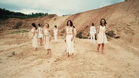4k 360 drone video canyon hill crater natural landscape. Group of women in white clothes dancing in circle. Ritual and ceremony. Sunset view. 