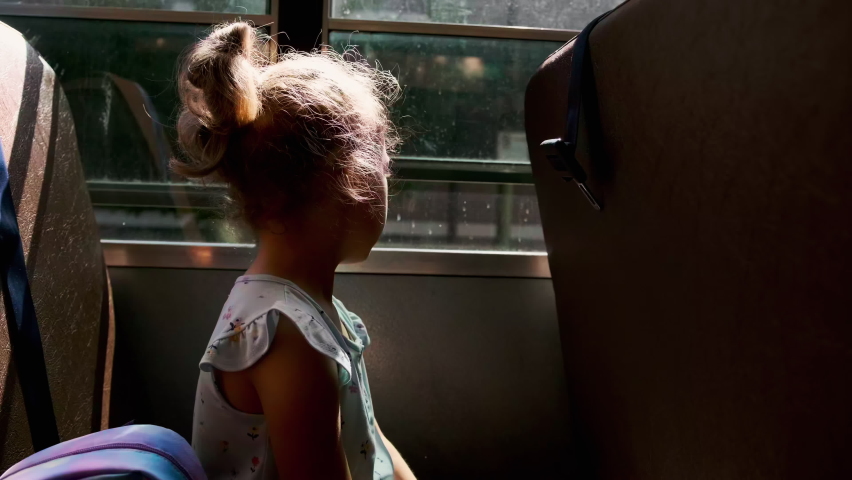 School girl riding in academic shuttle. Public education transportation. Slow motion. Close up