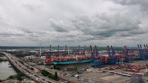 Hamburg, Germany - July 2022: Aerial panoramic view on the cranes and loaded cargo ships in Burchardkai Container Terminal (CTB) in the Port of Hamburg (Hamburger Hafen)