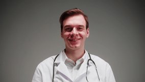 Happy doctor portrait, nurse, therapist. Medical worker smiling, posing on grey background in studio. Man wearing stethoscope, surgical uniform, looking in camera. Healthcare and medicine. - Powered by Shutterstock - Get 15% off with code: PIKWIZARD15