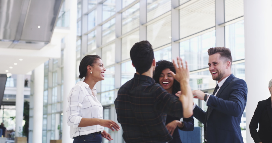 Team of businesspeople high five for success or good teamwork and job well done, looking excited and happy inside workplace. Diverse business colleagues celebrating winning a great successful Royalty-Free Stock Footage #1092852805