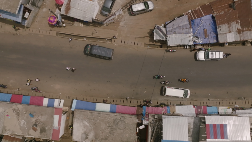 Top down aerial footage of cars moving across the road in Freetown, Sierra Leone.
