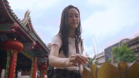 An Attractive girl praying at a Chinese shrine in Bangkok, Thailand. Stock Video