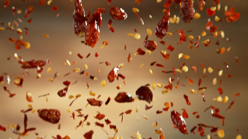 Falling of dry chilli peppers, close-up, macro shot. Filmed on high speed cinematic camera at 1000 fps.