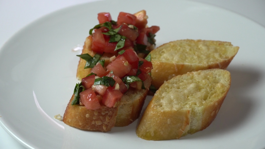 Classic tomato sandwich or Italian bruschetta with parsley tomato, garlic on toasted bread Royalty-Free Stock Footage #1092875607