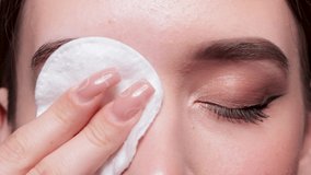 A young beautiful girl removes makeup with a cotton pad and micellar water from her face and eyes. - Powered by Shutterstock - Get 15% off with code: PIKWIZARD15