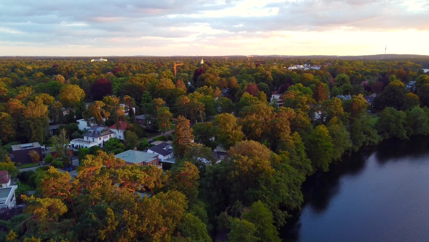 villas located directly on the lake
Breathtaking aerial view flight pedestal down drone footage of lake schlachtensee Berlin, golden summer sunset 2022. 4k Cinematic view from above by Philipp Marnitz