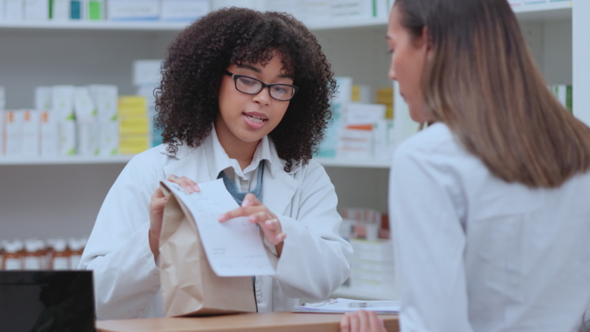 Doctor, medical professional and expert giving patient medicine, medication and pills working at a pharmacy. Happy, smiling and friendly female talking, discussing and advising client on Royalty-Free Stock Footage #1092891099