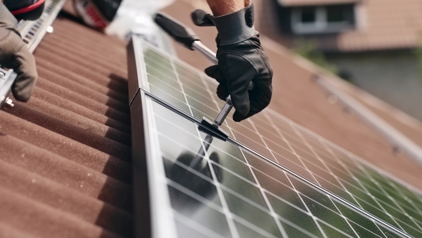 Worker installing solar panel on the roof, close up on hands | Shutterstock HD Video #1092893109
