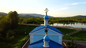 A village church with a blue dome and a gilded cross. The Cathedral church in honor of the Nativity of the Most Holy Theotokos in the urban-type settlement of Kuldur in the Jewish Autonomous Region. 