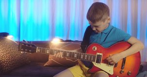 Boy son play guitar at home. Dad teaches child to play musical instruments. Music hobby, Create, learning own songs. SHARE THE LOVE, play our game. 4K video.	