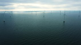 Aerial drone shot of oceanic wind turbines at the Rødsand wind farm in Denmark. Green energy is a promising alternative to fossil fuels and the need for a transition is urgent.  - Powered by Shutterstock - Get 15% off with code: PIKWIZARD15
