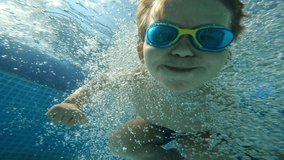 Male kid jumping to blue swimming pool bubbles water enjoy happy childhood underwater shot slow motion boy child in goggles floating surrounded by splashing summer vacation weekend outdoor activity - Powered by Shutterstock - Get 15% off with code: PIKWIZARD15