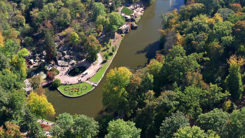 Beautiful flight above the trees. Autumn forest. Yellow, red, green leaves on the trees. Top view of a beautiful lake and a fountain.