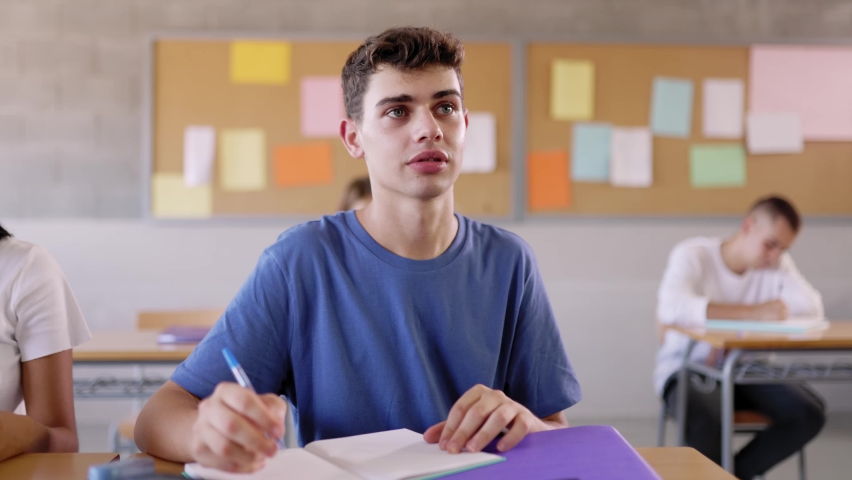 High school young student writing on notebook in class - Teenage boy sitting at desk doing exercise in classroom Royalty-Free Stock Footage #1092912079