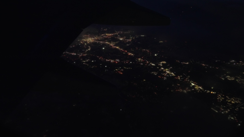 View Through Plane Window on a Night City Lights During the Flight. Panoramic Shot Royalty-Free Stock Footage #1092913059