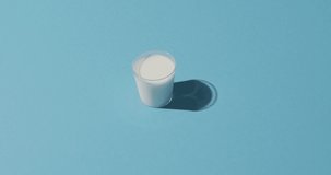 Video of glass of fresh milk over blue background. dairy products and healthy organic nutrition.