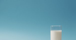 Video of glass of fresh milk over blue background. dairy products and healthy organic nutrition.
